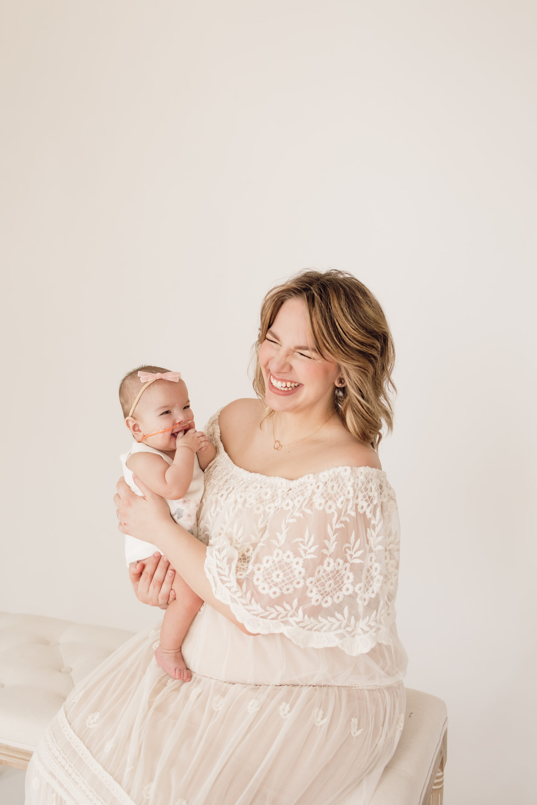 Mom smiling and holding her 6 month old baby during her milestone session taken by a Baby Photographer in Louisville