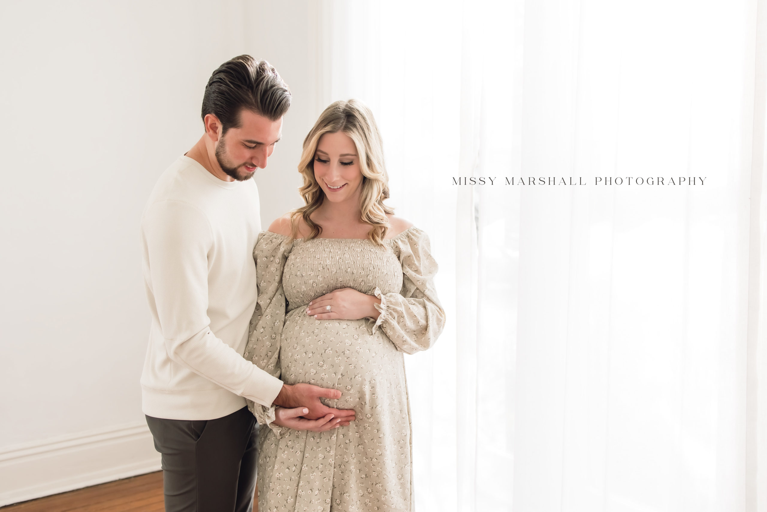 Louisville Newborn Photographers | Mom holding her pregnant belly during her maternity session in a bright studio in Louisville KY taken by Missy Marshall Photography
