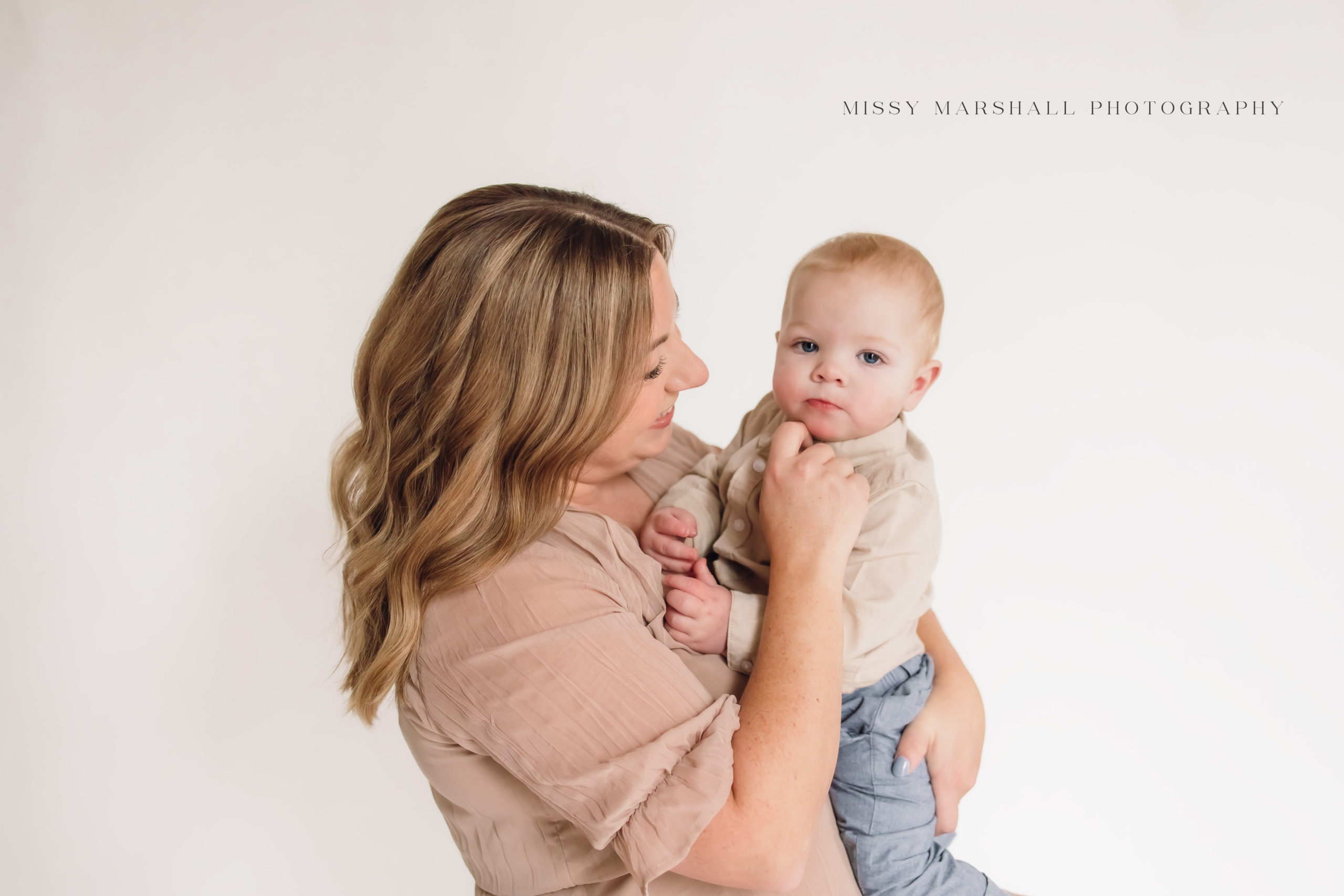 Mom holding her one year old baby in a bright studio in Louisville KY taken by Missy Marshall Photography