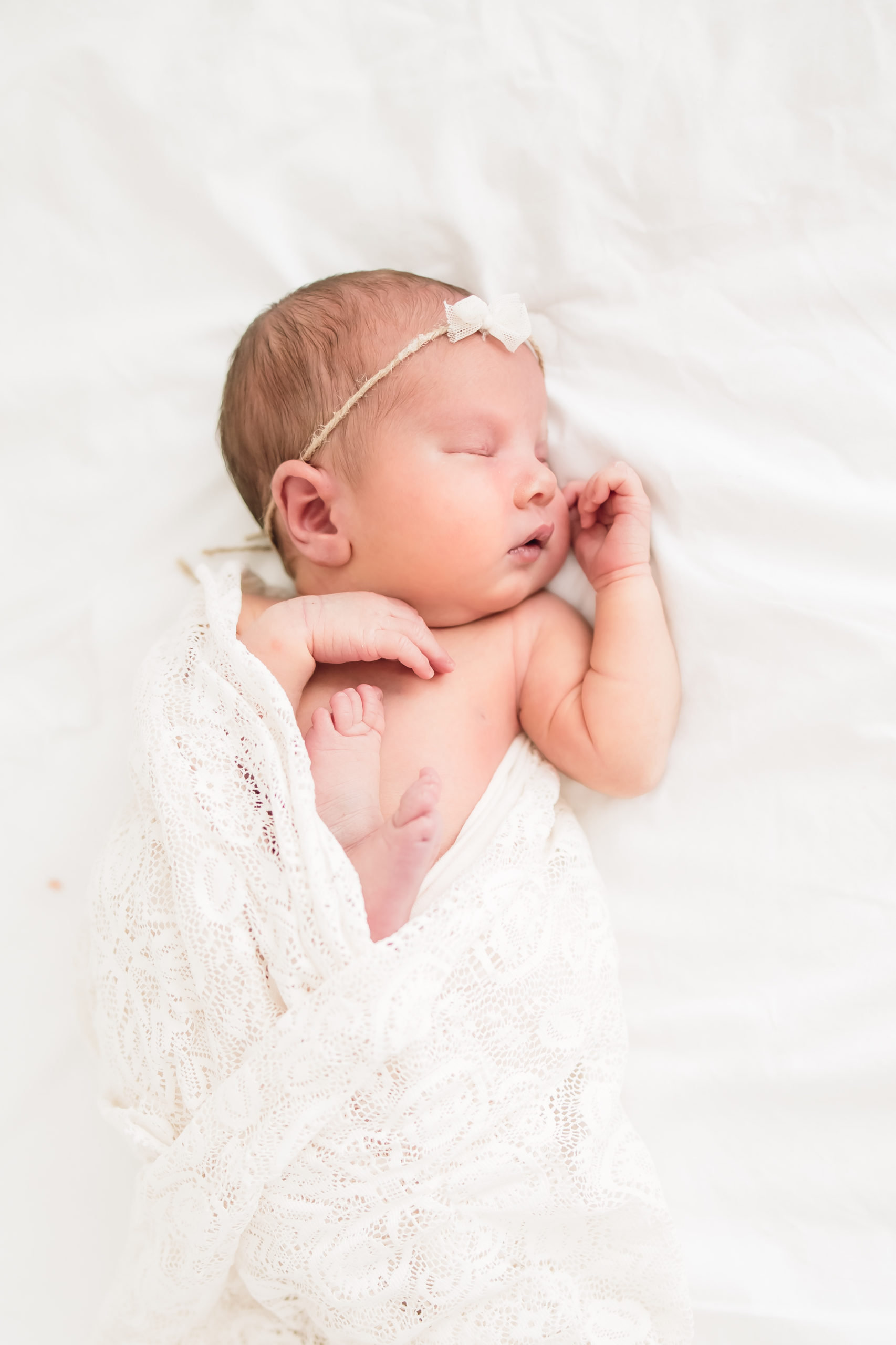 Newborn baby sleeping in a bright white studio taken by a newborn photographer in Louisville