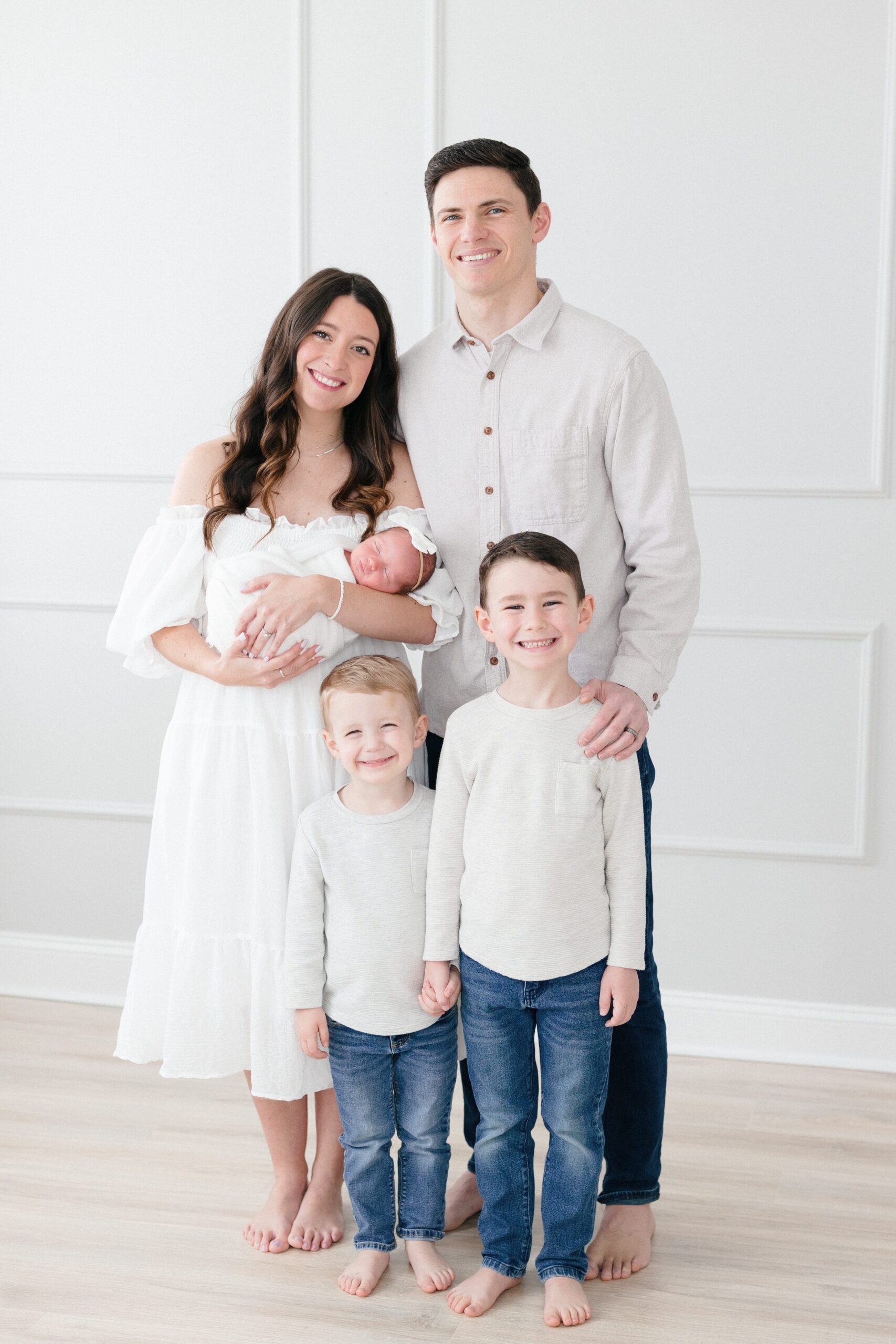 Family of five who learned how to prepare for their newborn session - smiling in a Louisville KY newborn photography studio.