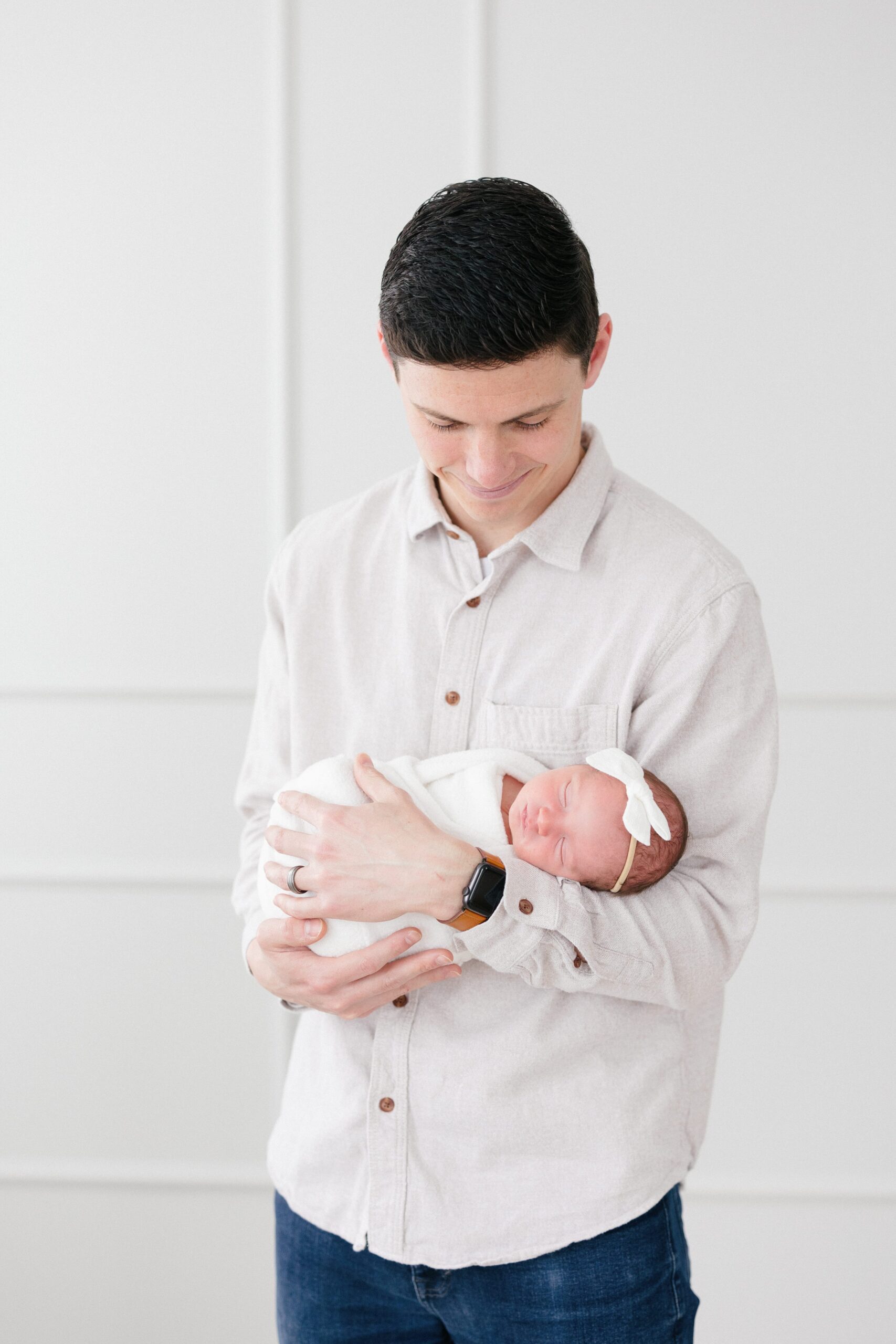Portrait of a dad holding his newborn baby girl taken by newborn photographer missy marshall