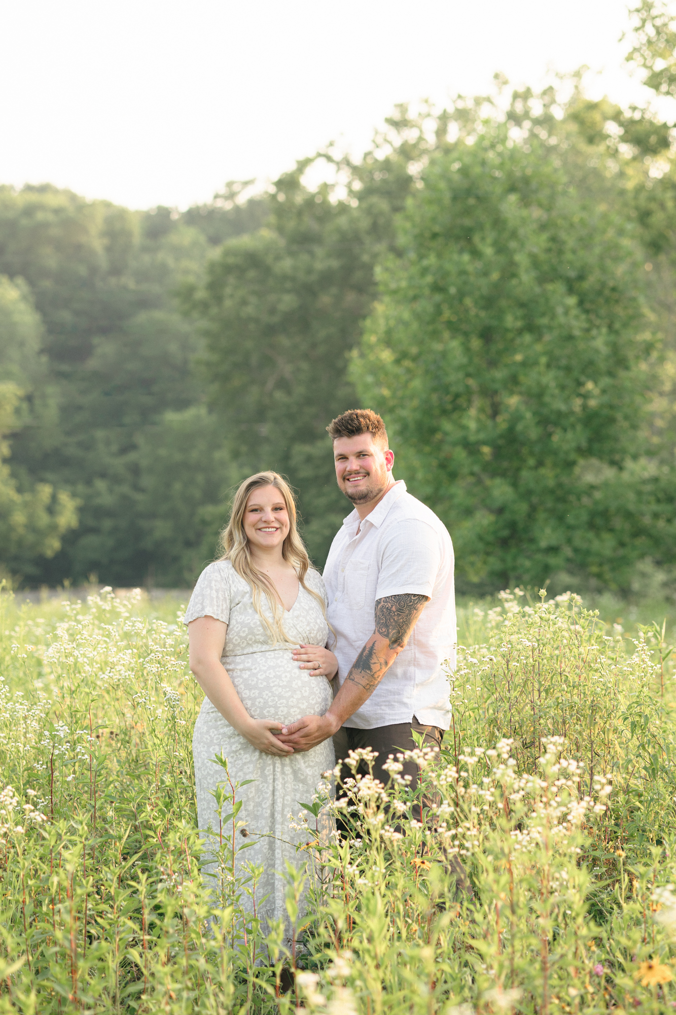 Portrait of expecting parents smiling at the camera taken by one of the best Louisville maternity photographers Missy Marshall